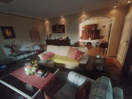 Wohnzimmer mit Blick ins Esszimmer mit Kachelofen