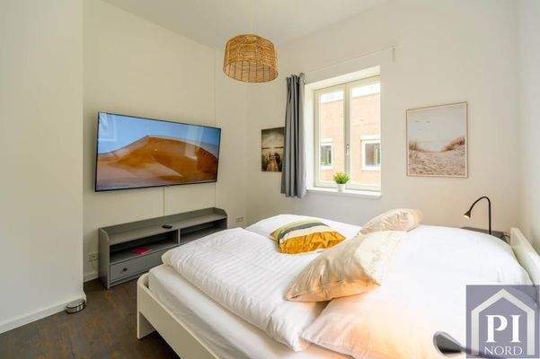 Gemütliches Schlafzimmer mit großem Smart-TV