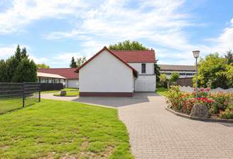 Helles Landhaus mit blühendem Garten.png