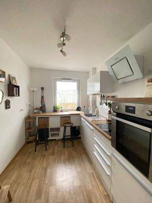 Küche mit Blick Richtung Fenster mit weißen Wänden, PVC Boden in Holzoptik und mietereigenen Kücheneinrichtung.jpg