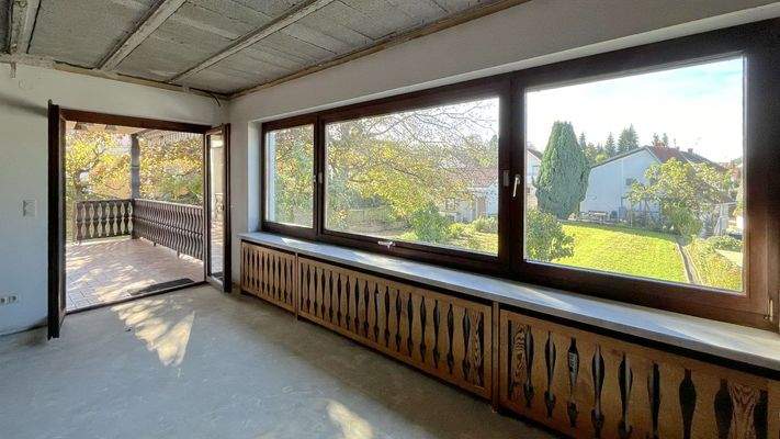 Wohnzimmer mit Zugang zum überdachten Balkon und B