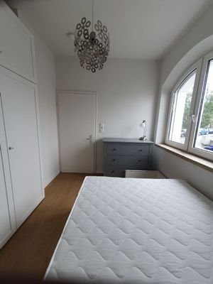 Schlafzimmer mit Bett, Sideboard und Schrank