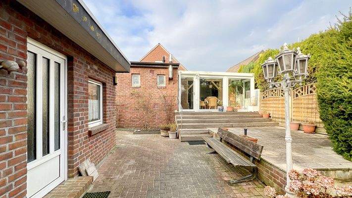 Hausrückseite mit Wintergarten, Terrasse und Nebengebäude