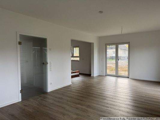 Wohnzimmer mit Zugang zur offen gestalteten Küche