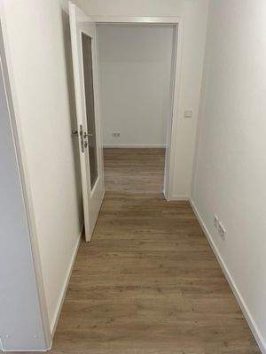 Weisser Flur mit Holzboden