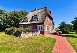 Inbegriff norddeutscher Architektur – Traditionelles Reetdachhaus mit rotem Klinker
