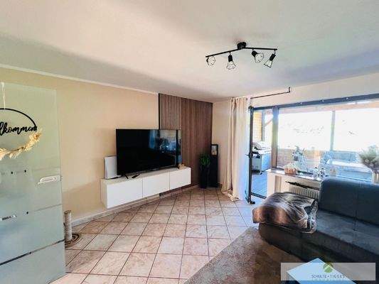 Ihr gemütliches Wohnzimmer mit Zugang zur Loggia + zum offenen Esszimmer + Küche