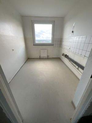 Beispielhafte Küche mit weißem Fliesenspiegel und hellem Linoleumboden