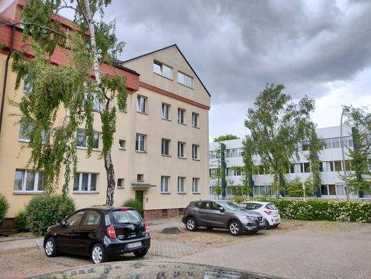 Wohngebäude v Parkplatz