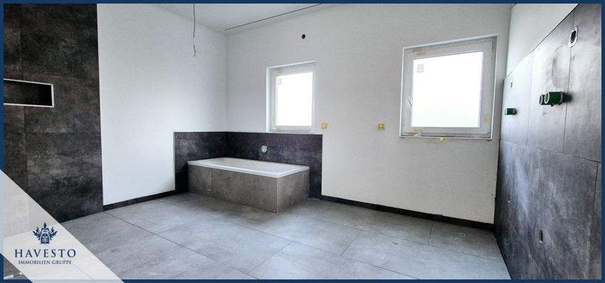 Blick in das große Badezimmer mit Badewanne und bodentiefer Dusche