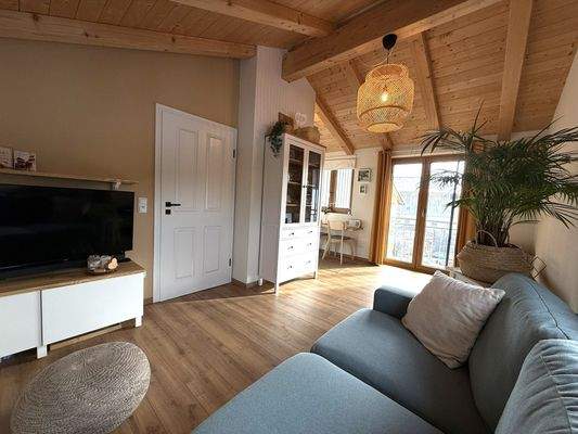 Wohnzimmer mit Sichtdachstuhl im OG