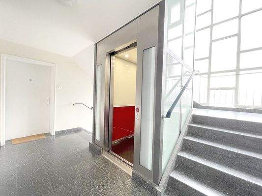 Neuer Lift im hellen Treppenhaus