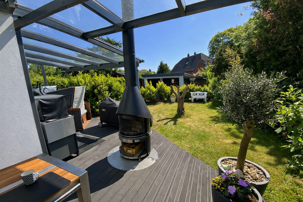 Gemütliche Terasse mit Kamin und Garten