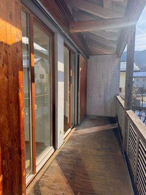 Sonniger Balkon mit Holzgeländer