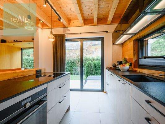 Küche mit Kochinsel und Zugang zur Terrasse