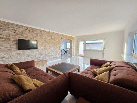 Wohnzimmer mit Zugang zur Terrasse und Blick ins Esszimmer