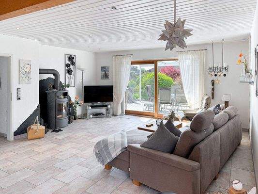 Wohnbereich mit Kaminofen und Zugang zur Terrasse