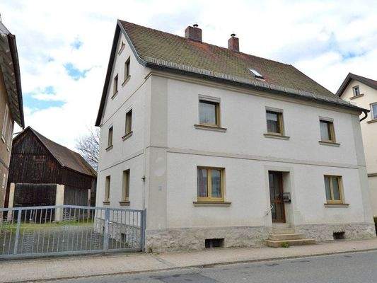 Hausansicht Straßenseite mit Haupteingang und Toreinfahrt zum Grundstück