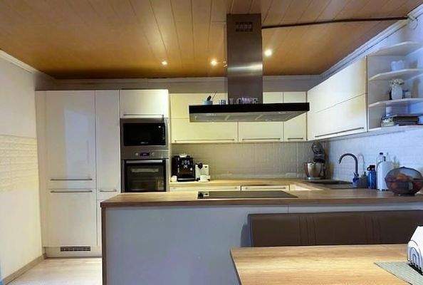 Komplettküche mit Geräten, daneben Essbereich