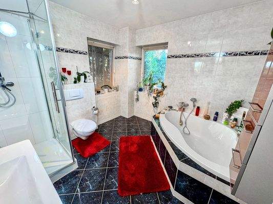 Das Badezimmer mit Eckwanne und Dusche