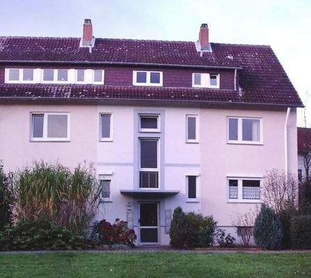 Gebäude Vorderseite des mehrstöckigen Wohnhauses umgeben von Grünanlagen mit Bäumen und Sträuchern