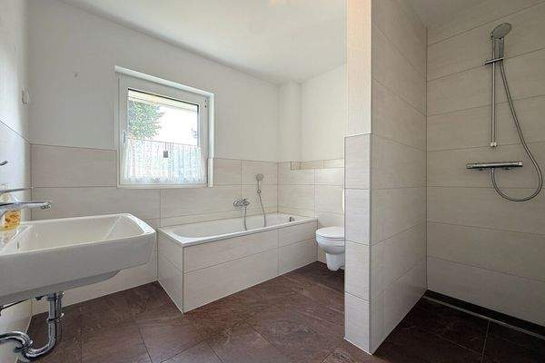 Badezimmer mit Badewanne und ebenerdiger Dusche