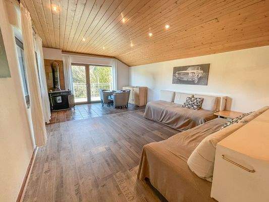 Wohnbereich mit Kamin und Zugang zum Balkon