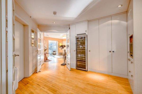 Weitläufiger Flur mit eleganten Einbauschränken und integriertem Weinschrank