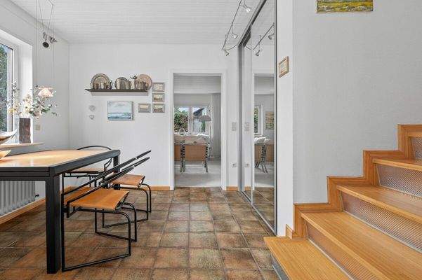 Wohnraum mit offenem Treppenaufgang, gesehen vom Eingang