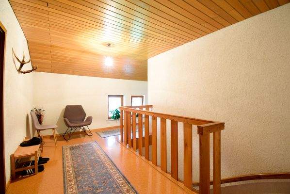 Diele im Obergeschoss mit Zugang zu den Doppelzimmern und der unsanierten Wohnung