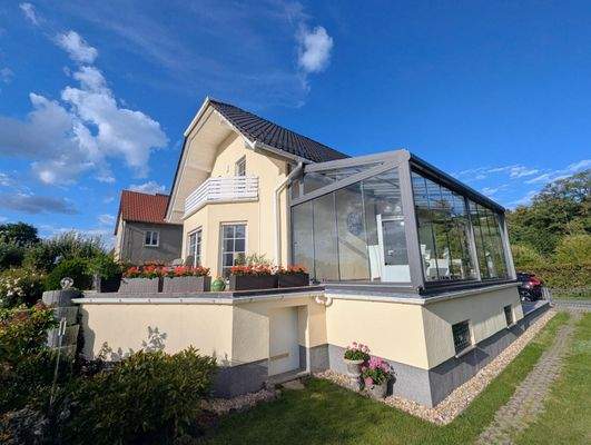 Ansicht des Wohnhauses mit Sommergarten und Terrasse