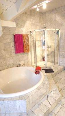 Die begehbare Dusche. Und eine runde
Badewanne, für die kleinen Zwerge mit
Mama und Papa