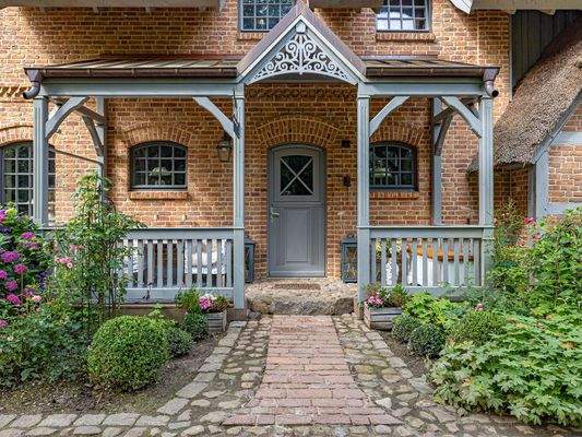 Eingang der Eigentümer-Haushälfte mit Holzveranda