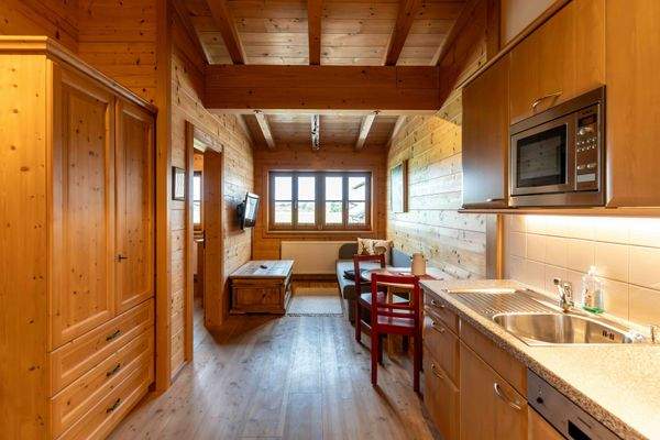 Wohnzimmer mit Sofa, Couchtisch und TV, kombiniert mit Essbereich in Holzoptik.