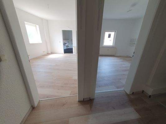 1. OG Ansicht Schlafzimmer und Wohnküche vom Flur.jpg