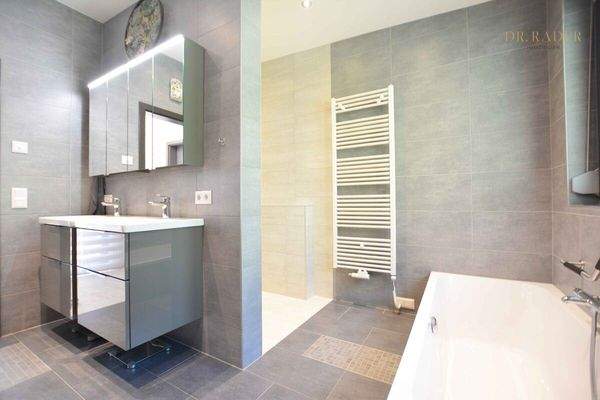 Badezimmer mit Badewanne, Dusche und Fenster