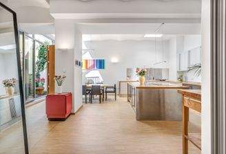 Lichtdurchflutetes Esszimmer mit offen gestalteter Küche.