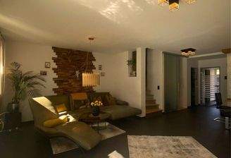 Großzügiges Wohnzimmer mit stilvoller Wandgestaltung in Holz