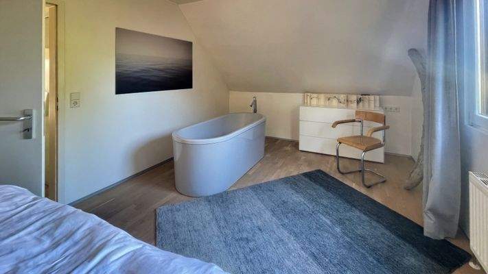 Elternschlafzimmer mit freistehender Badewanne