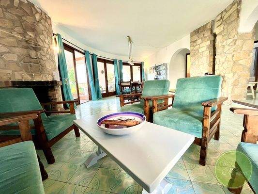 Wohnbereich mit Kamin und Zugang zur Terrasse  