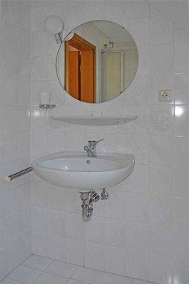 Bad mit Waschbecken und Spiegel