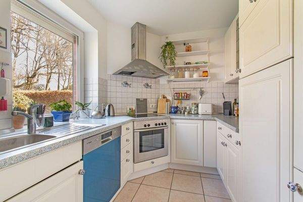 Zeitlose Einbauküche mit Blick in den Garten