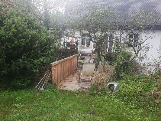 von der Terrasse über die Brücke zum Garten  