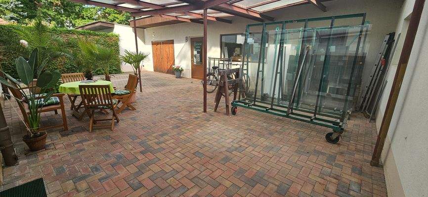 Hofbereich mit überdachter Terrasse und Blick auf das Nebengebäude