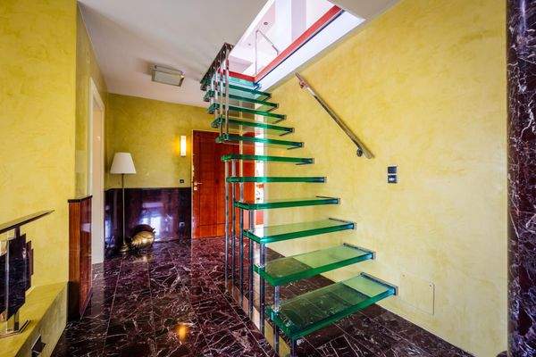 Eine Glastreppe führt ins Dachgeschoss