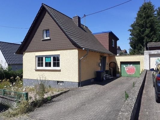 Ansicht mit großer Einfahrt und Garage