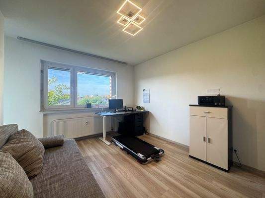 Helles Arbeitszimmer mit Zugang zum Balkon.