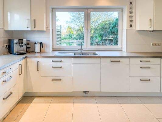 Moderne Einbauküche mit Blick auf den Schwimmteich