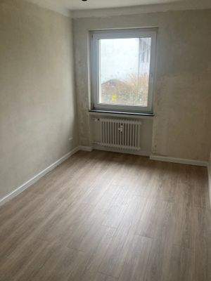 Schlafzimmer mit Vinyl-Bodenbelag in Holzoptik mit tapezierfähigen Wänden.