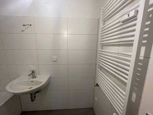 Badezimmer mit Waschbecken und Handtuchheizkörper, weiß gefliest